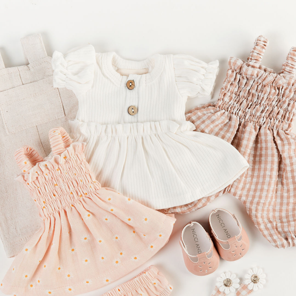 Flat lay featuring the Florence Smocked Jumpsuit, Puff Sleeve Dress, Smocked Dress Set and Oat Mary Jane Shoes for 34–38cm dolls.