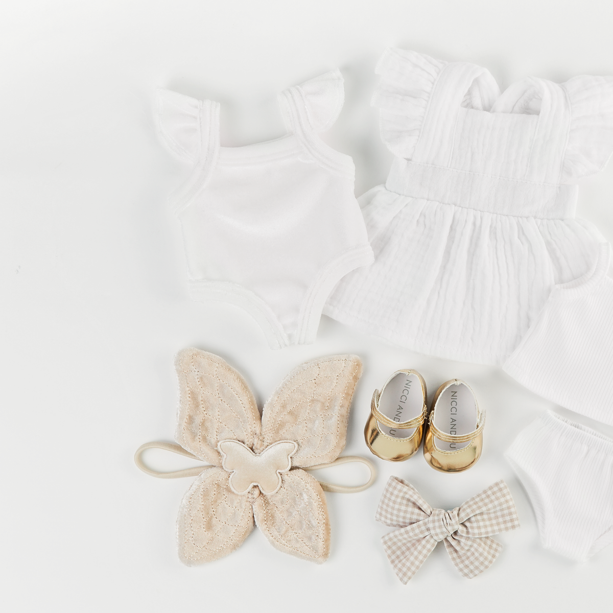 Flat lay featuring the Ivory Frilled Velvet Singlet Bodysuit, Ivory Apron Dress, Beige Velvet Fairy Wings, Gold Mary Jane Shoes and Beige Gingham Pinwheel Bow for 34–38cm dolls.