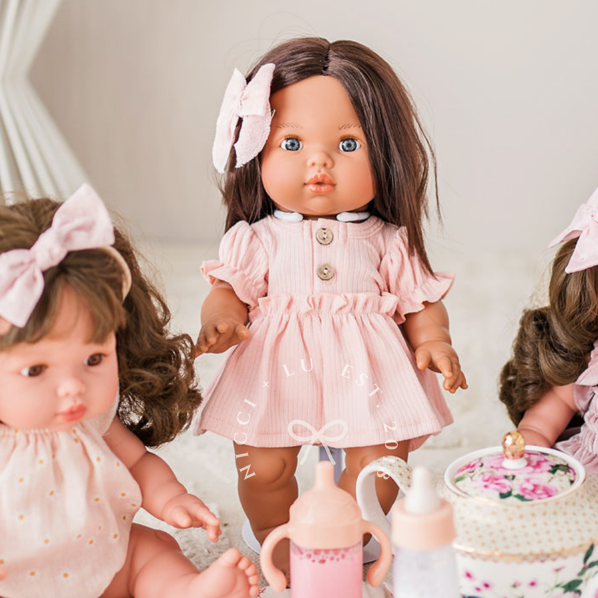 34cm Mini Colettos Isabel brunette doll in rose pink puff sleeve dress styled with pretend play tea set by Nicci and Lu lifestyle.