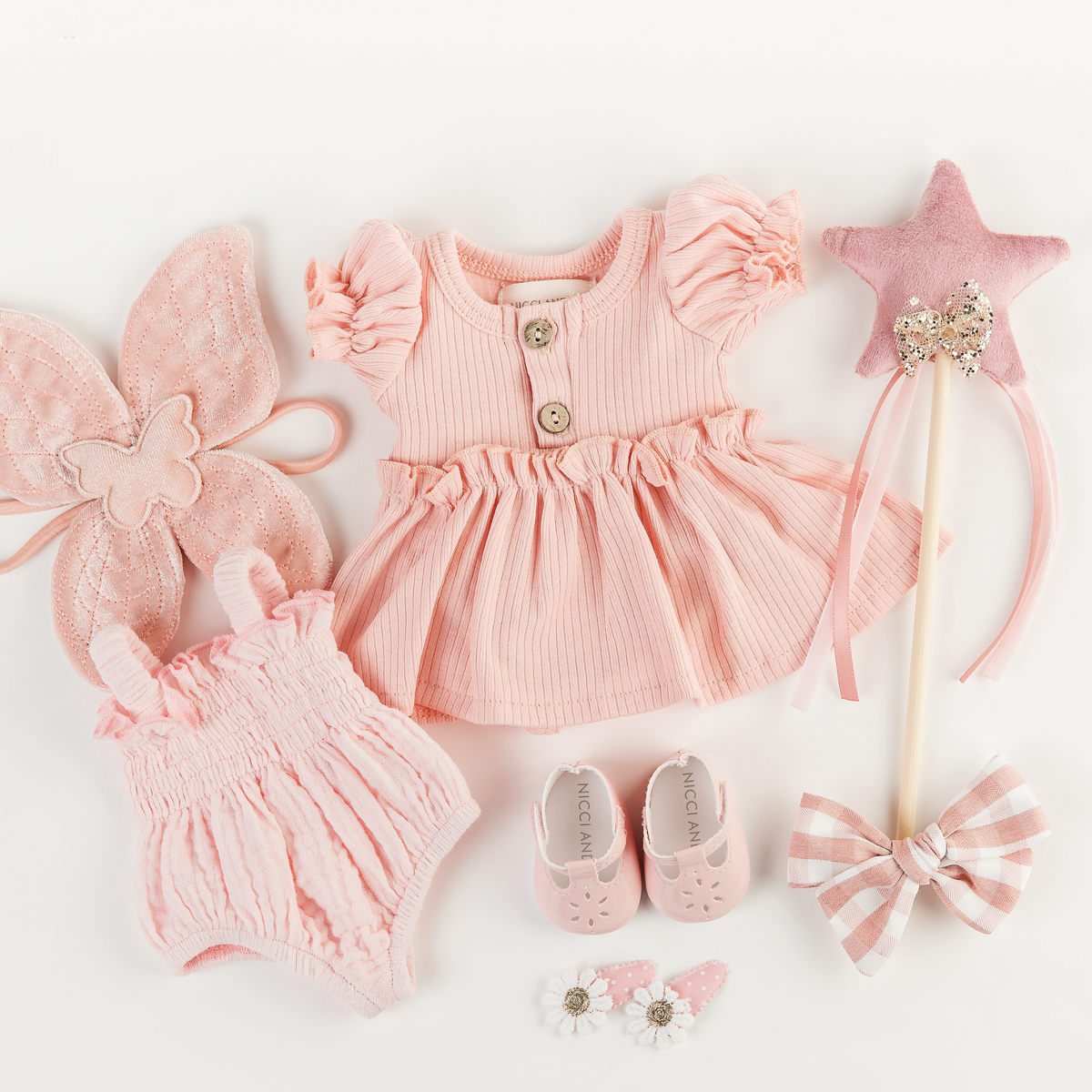 Flat lay of rose pink kennedy puff sleeve dress, mary jane shoes, gingham hair bow and star fairy wand accessories for 34-38cm dolls by Nicci and Lu