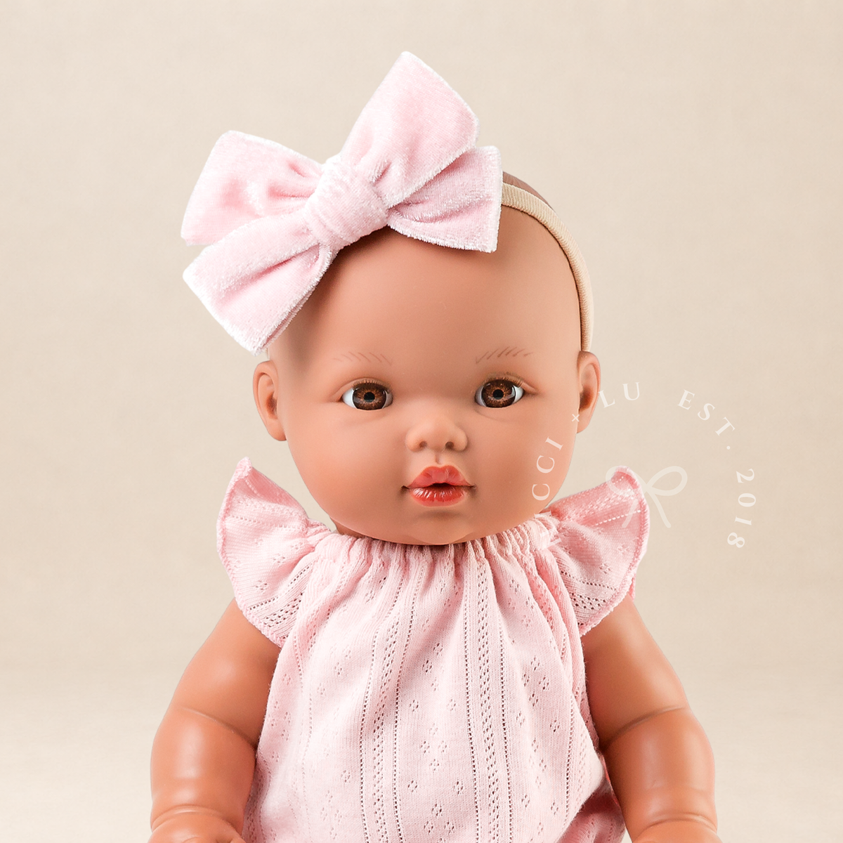 Portrait of 34cm Mini Colettos Alba wearing the Willow Pointelle Romper in Pink with Soft Pink Mary Jane Shoes.