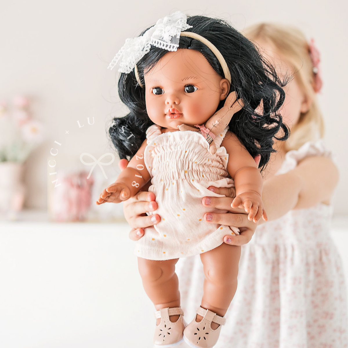 Mini Colettos Aurora wearing the Billie Smocked Dress in Daisy Print Muslin.