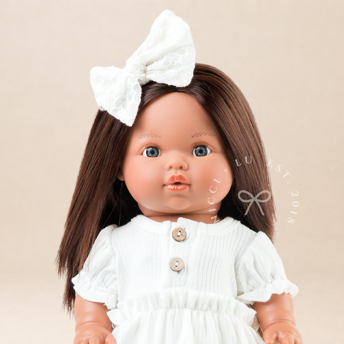 34cm Mini Colettos brunette doll Isabel wearing white puff sleeve dress with hair bow by Nicci and Lu