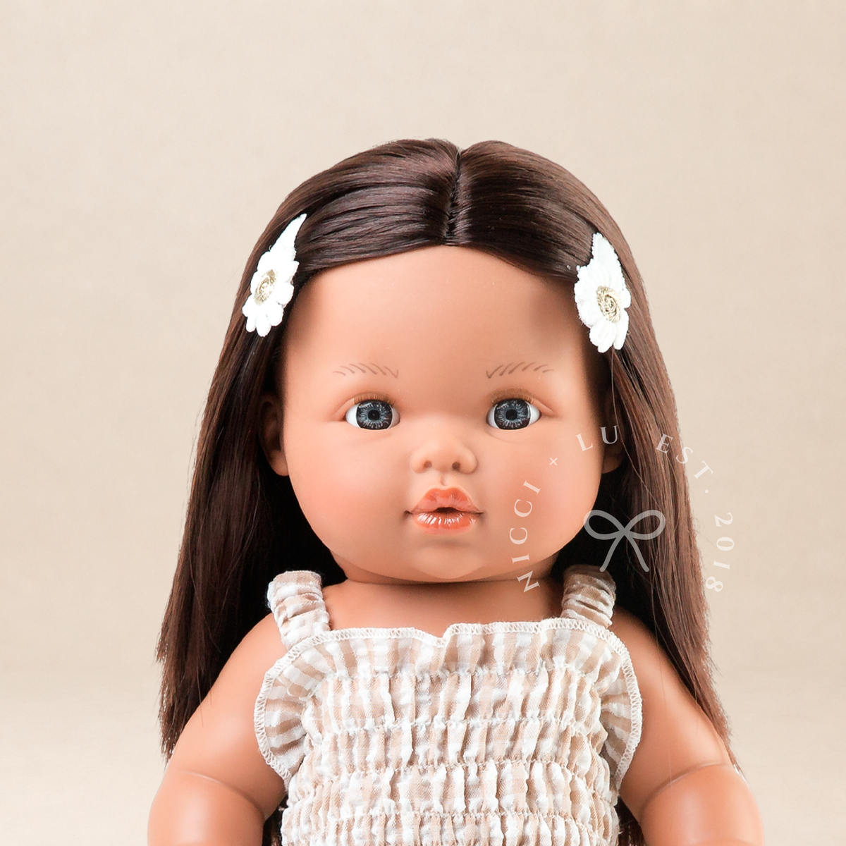 Portrait of Mini Colettos Isabel wearing the Florence Smocked Jumpsuit in Beige Gingham.