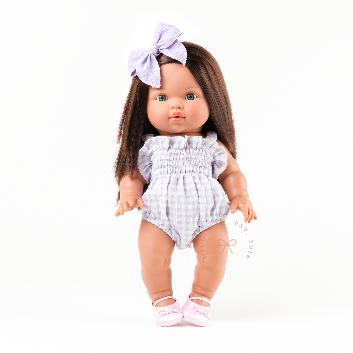 Mini Colettos Isabel doll wearing the Olivia Smocked Bubble Romper in Lilac Gingham with Soft pink ballet flats doll shoes.