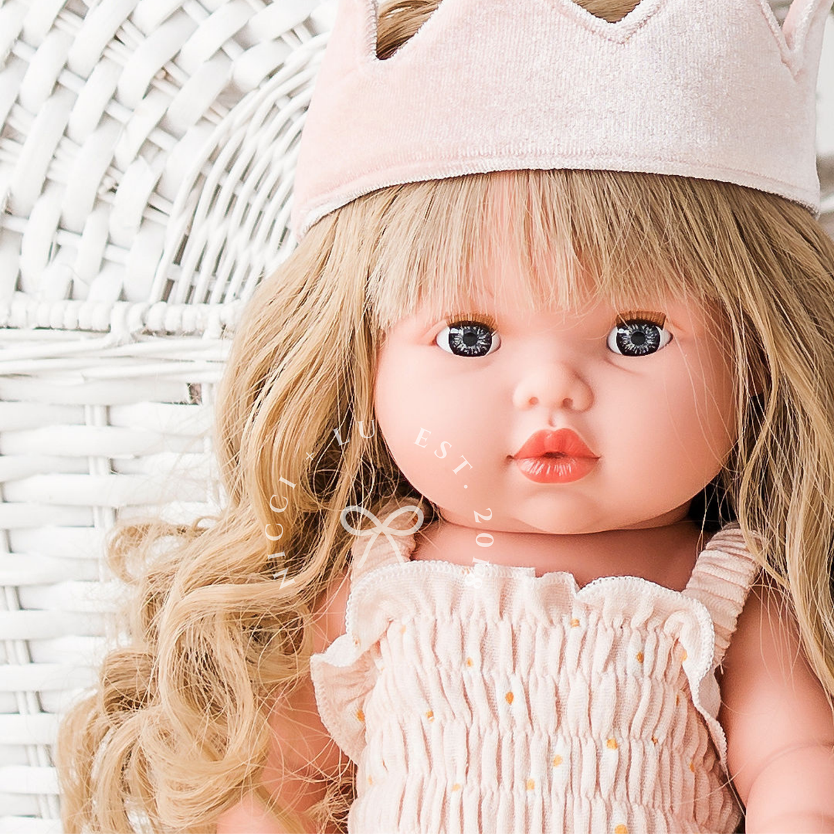 Portrait of Mini Colettos Lyla wearing the Florence Smocked Jumpsuit in Daisy Print Muslin with the Ballet Pink Fairy Crown.