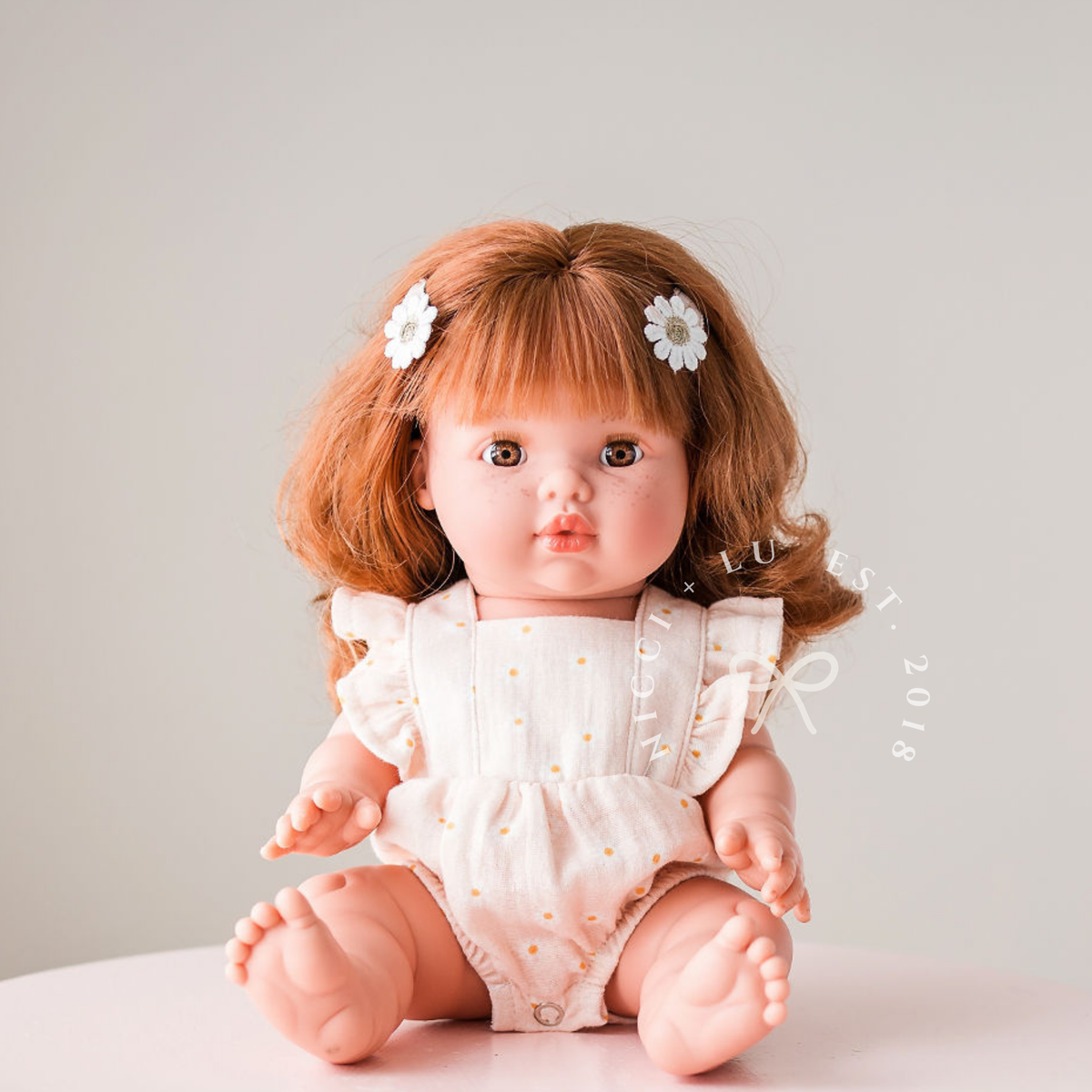 Portrait of Mini Colettos Sophia wearing the Elodie Frilled Bubble Playsuit in Daisy Print Muslin.