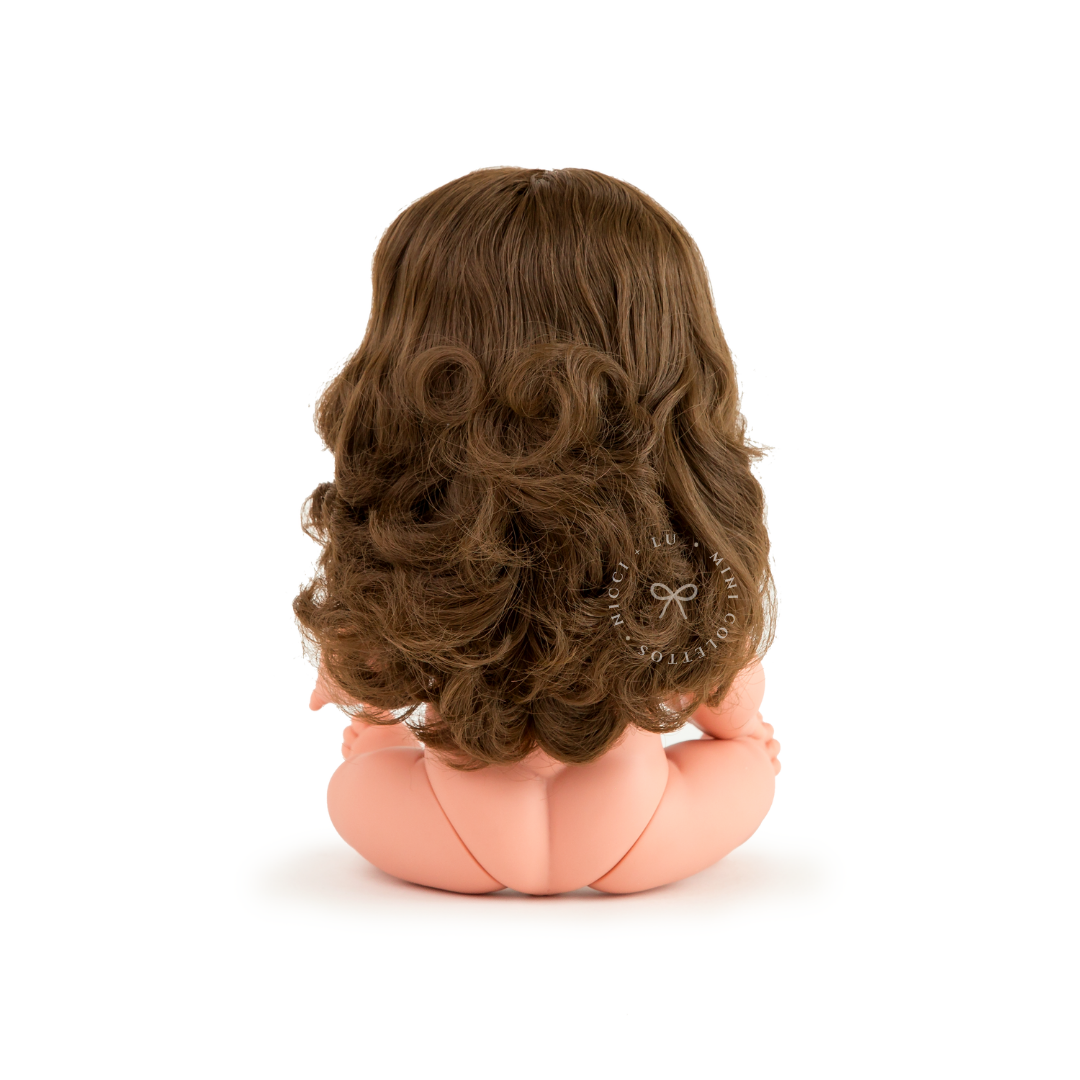 The back view of Harper showcases her beautiful thick brown hair, styled in soft, voluminous waves and curls. This photograph highlights the texture and length of the 34cm Mini Colettos Harper doll's hairstyle.
