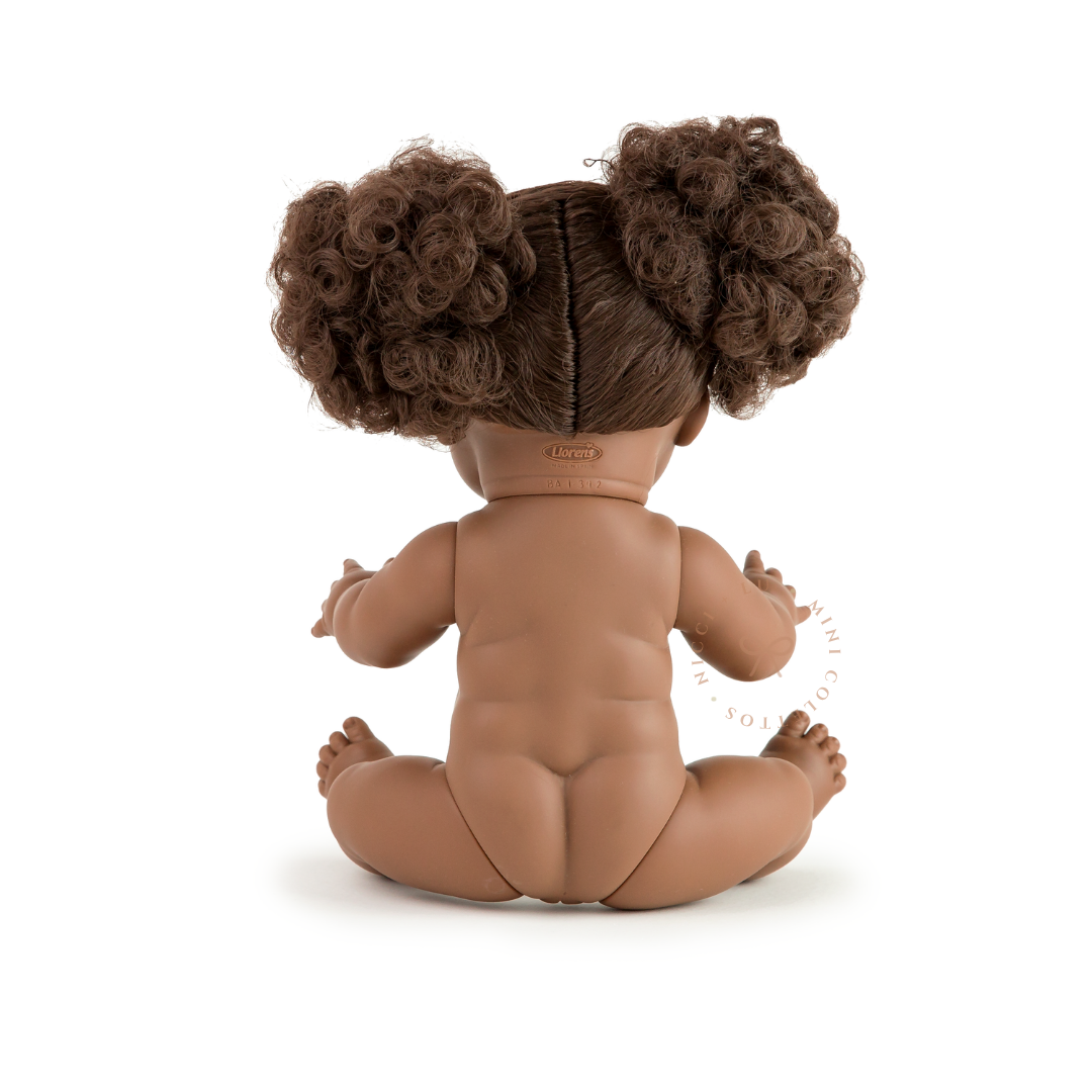 The back view of Jedda showcases her two beautiful, voluminous dark curly hair puffs and anatomically correct doll body. This photograph highlights the texture and styling of the 34cm Mini Colettos Jedda doll's hair.