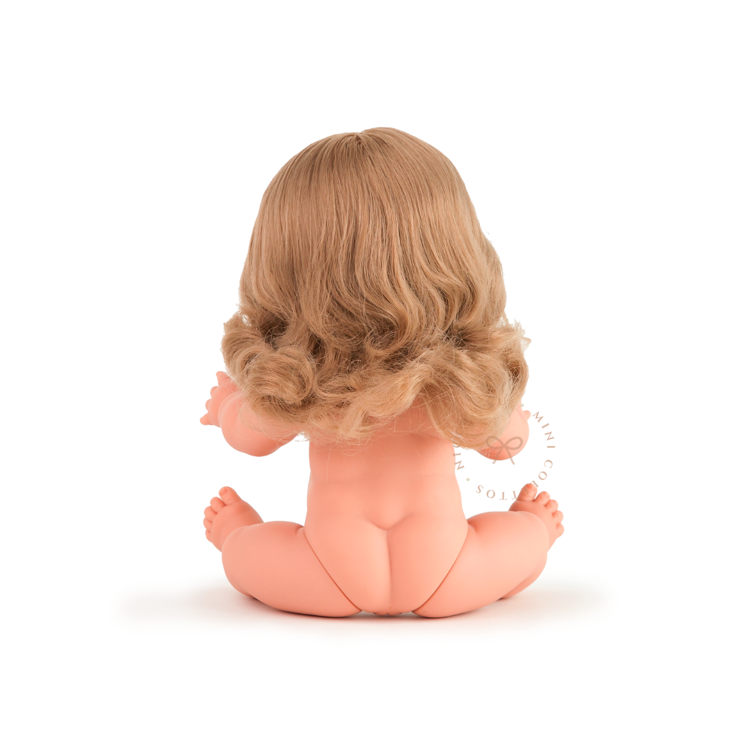 Rear view of Mini Colettos Kate seated undressed, showing her shoulder-length blonde hair with curled ends.
