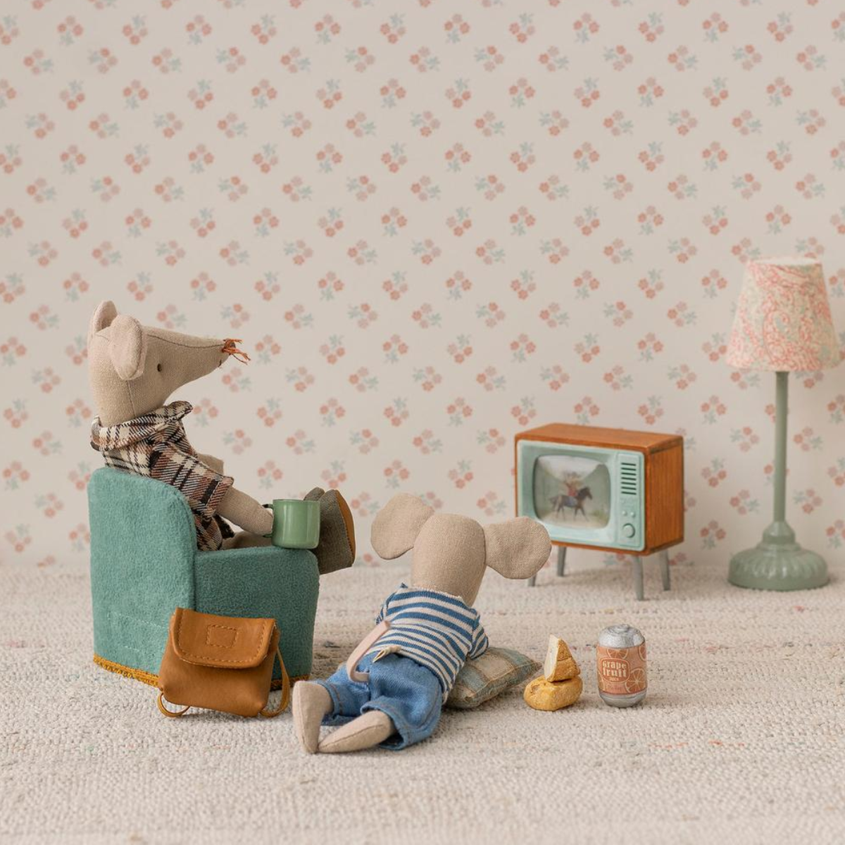 Two tMaileg Mice in a room with a small Maileg TV, lamp, and furniture.