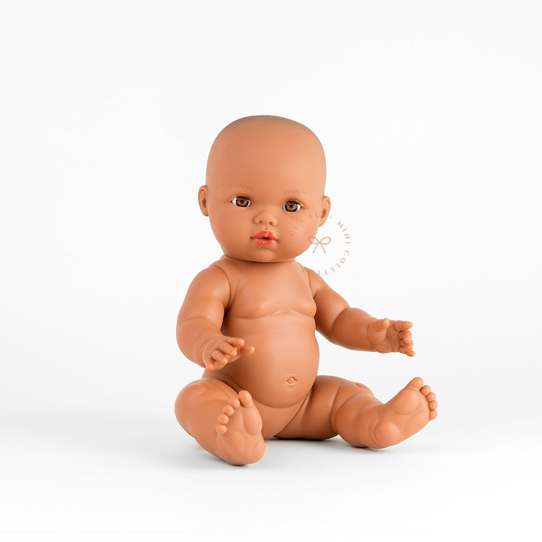 Mini Colettos Alba bald baby doll seated undressed, with warm brown eyes and rounded cheeks.