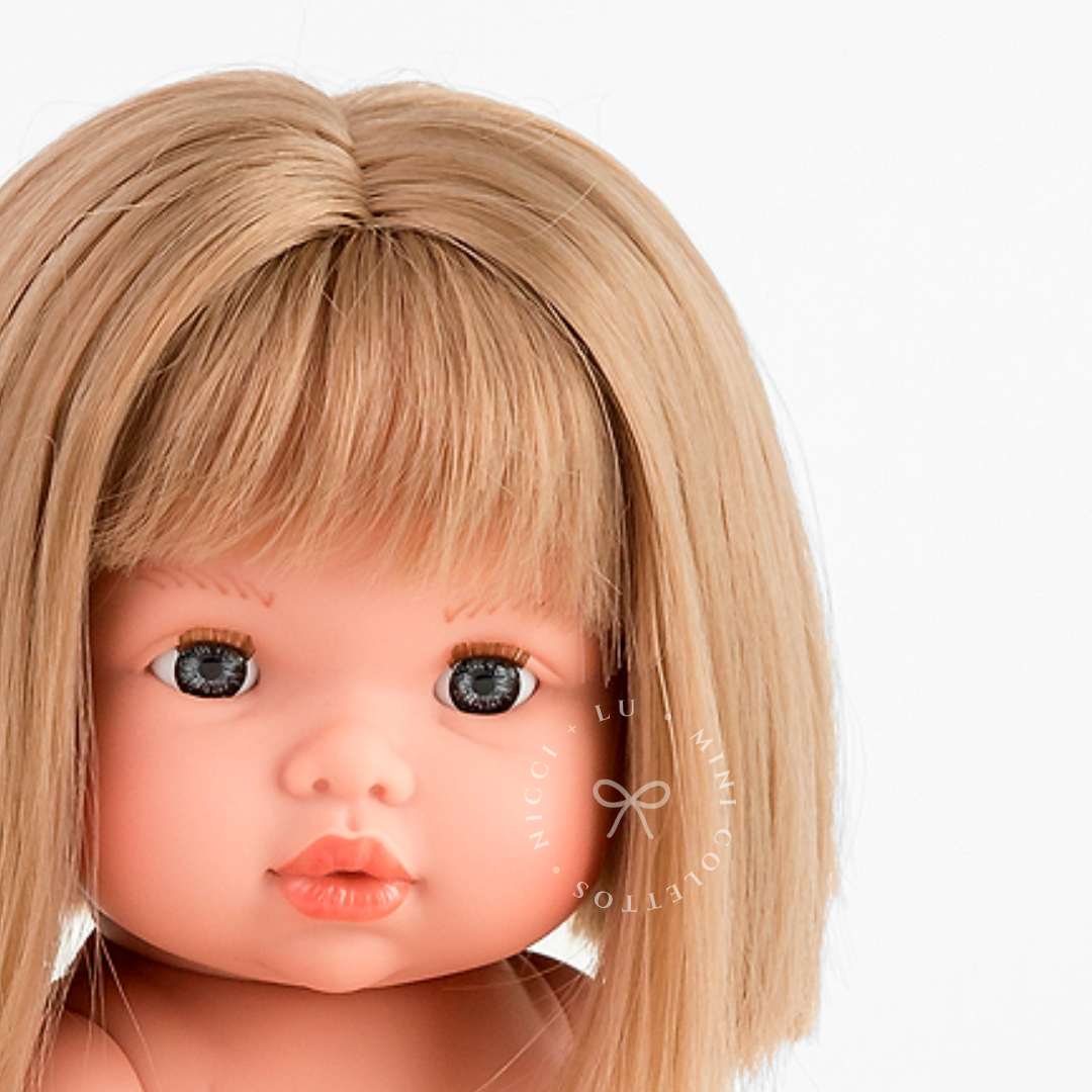 Charlotte's expressive blue-grey eyes, delicate lips and neatly trimmed blonde fringe are beautifully captured in this portrait. Her short, straight bob gives the 34cm Mini Colettos doll a sweet, timeless appearance.