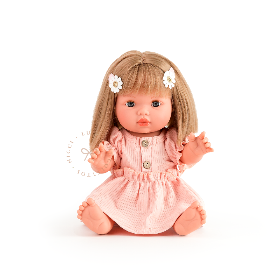 Charlotte looks adorable dressed in Kennedy Puff sleeve romper dress with delicate button detailing and pretty white floral hair clips. Her blonde bob completes this charming outfit, showcasing the 34cm Mini Colettos doll styled for imaginative play.
