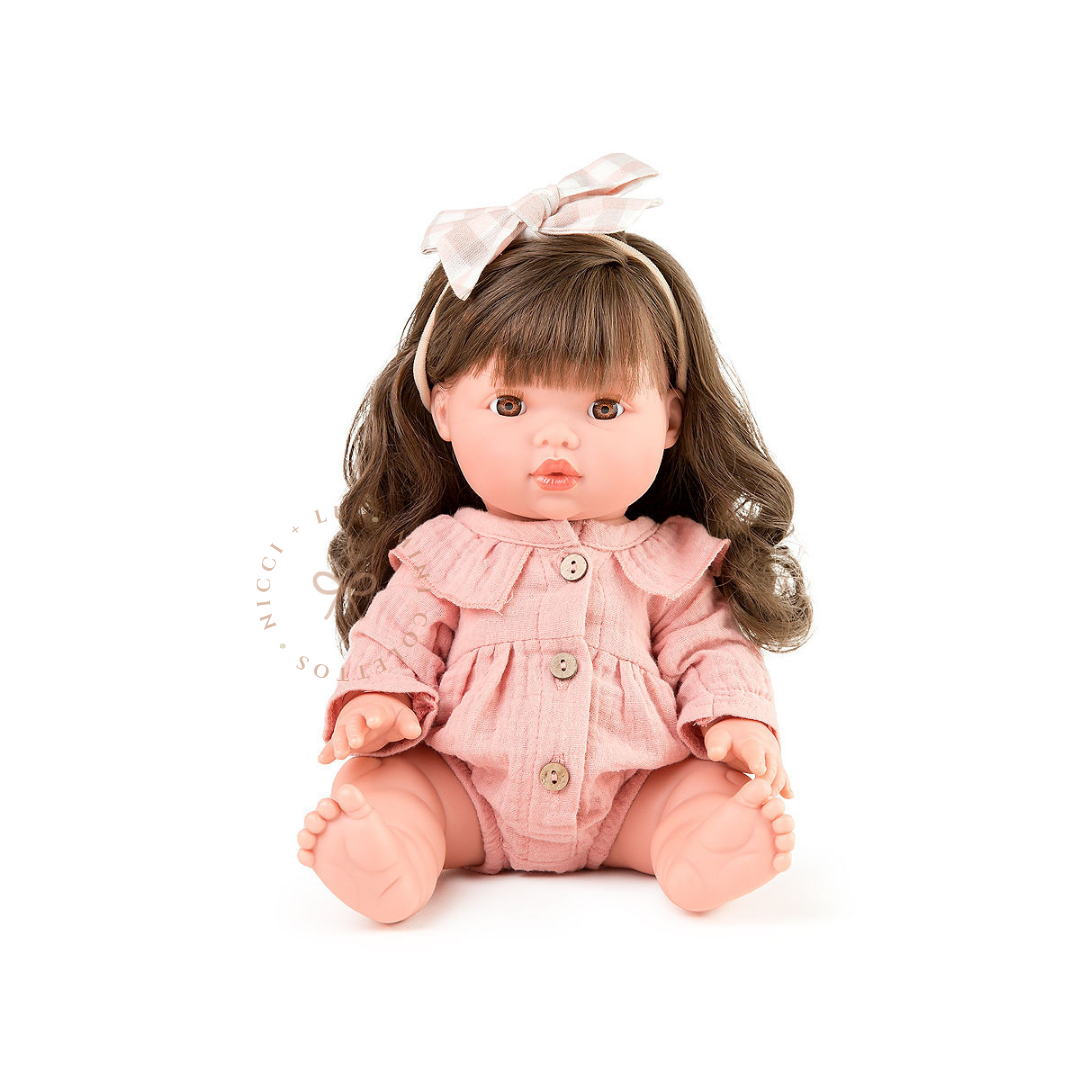 Hailee looks beautiful dressed in a Rose Blush Muslin Playsuit with delicate button detailing and a pastel hair bow. Her gorgeous brown curls complete the charming outfit, showcasing the 34cm Mini Colettos doll dressed for imaginative play.