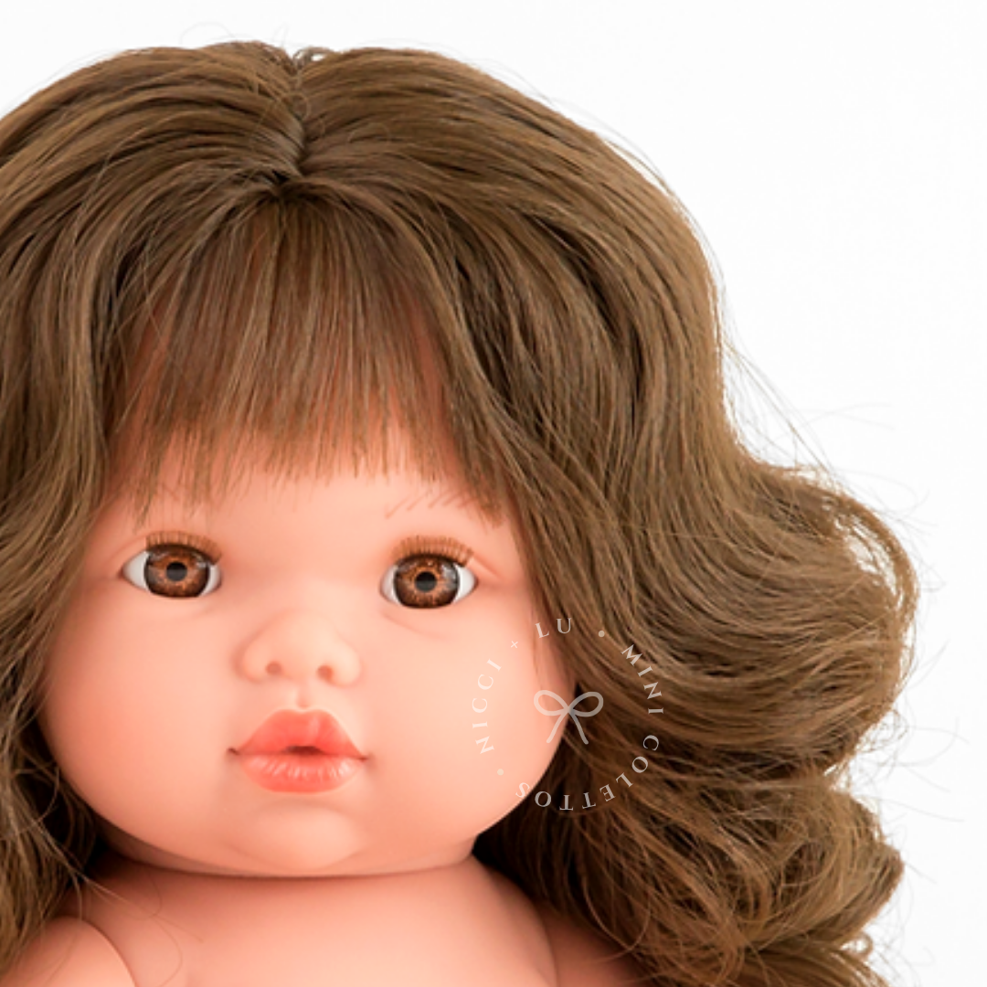 Discover Harper's sweet face, featuring expressive brown eyes, softly rounded cheeks and beautiful thick brown curls. Her wavy hair and delicate fringe give the 34cm Mini Colettos doll a charming appearance.