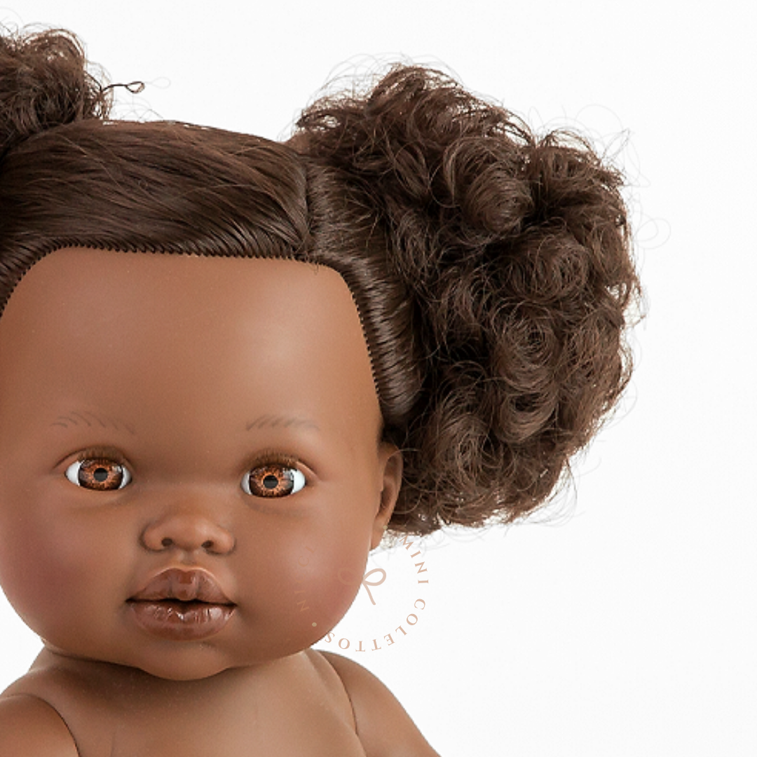 Jedda's expressive brown eyes, delicate lips and beautifully textured dark curls are captured in this detailed portrait. Her distinctive hairstyle gives the 34cm Mini Colettos doll a charming appearance.