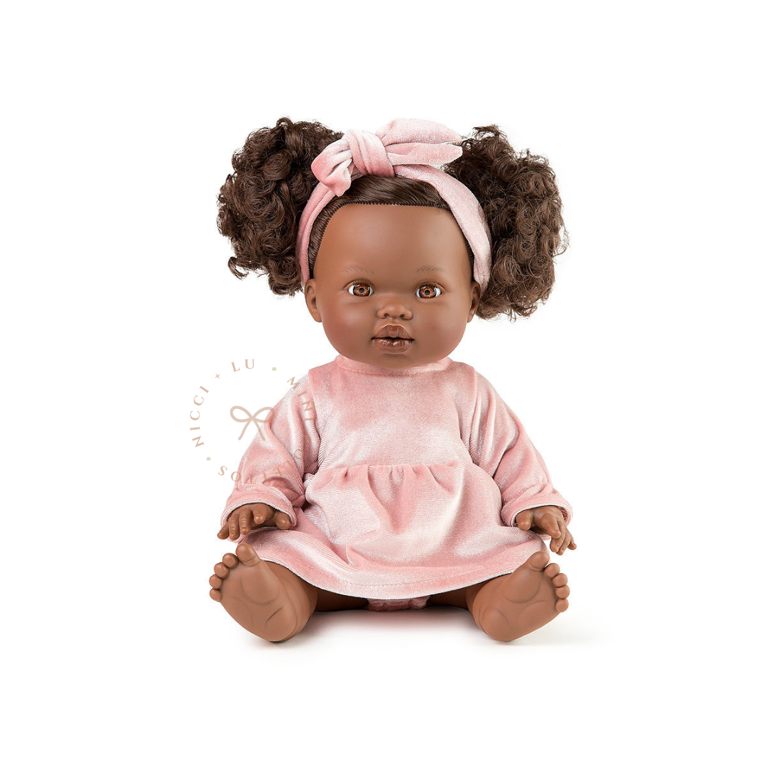Jedda looks adorable dressed in a Mae velvet dress set in Rose blush with her beautiful curly hair styled into two playful puffs. This styled photograph showcases the 34cm Mini Colettos doll dressed for imaginative childhood adventures.