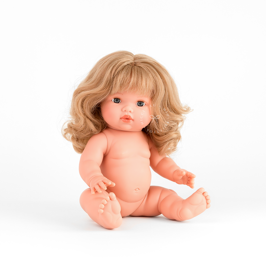 Kate looks adorable wearing a Muslin Flutter Romper in  pink with delicate ruffle detailing and a white hair bow. Her beautiful blonde curls complete the look, showcasing the 34cm Mini Colettos doll dressed in a sweet pastel outfit.