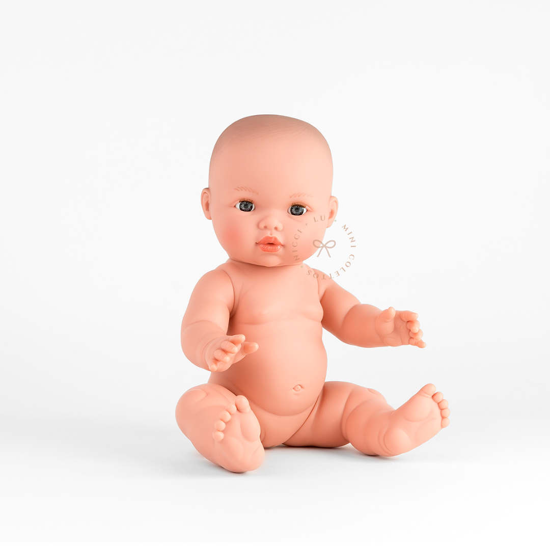 Mila looks adorable dressed in a rose pink lilly ribbed jumpsuit romper with delicate ruffle sleeves and a white bow headband. This styled photograph showcases the 34cm Mini Colettos bald doll dressed for imaginative baby care play.