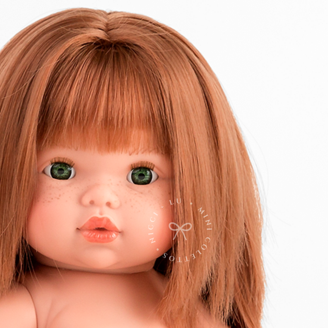 Nicole's delicate freckles, beautiful green eyes and rich copper-red hair are captured in this detailed portrait. Her straight fringe and softly rounded facial features give this 34cm Mini Colettos doll a distinctive appearance.