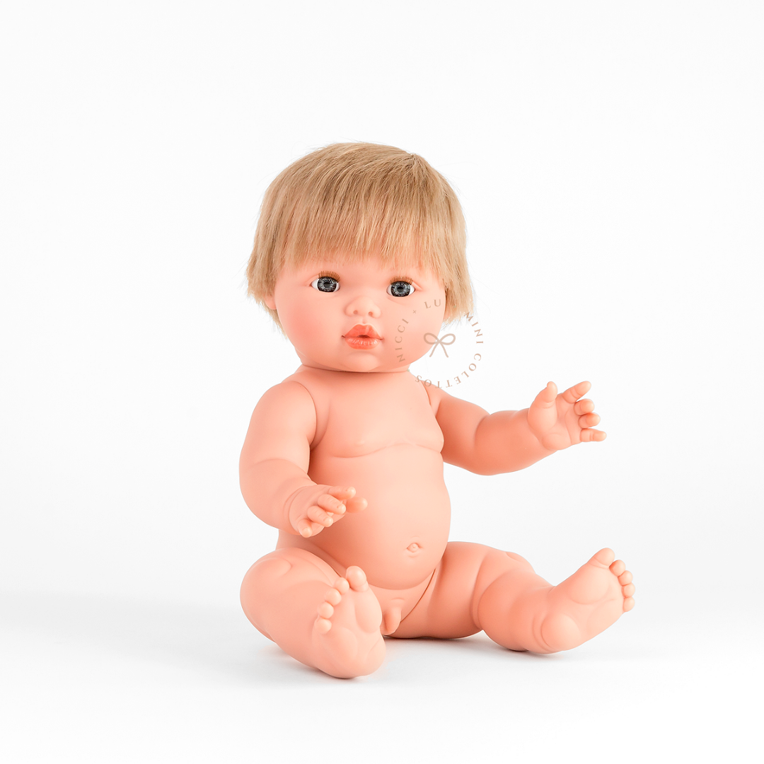 Oliver looks adorable dressed in a Luca ribbed bubble romper in ivory with front button detailing. His blonde hair and sweet expression complete this charming outfit, showcasing the 34cm Mini Colettos doll styled for imaginative play.