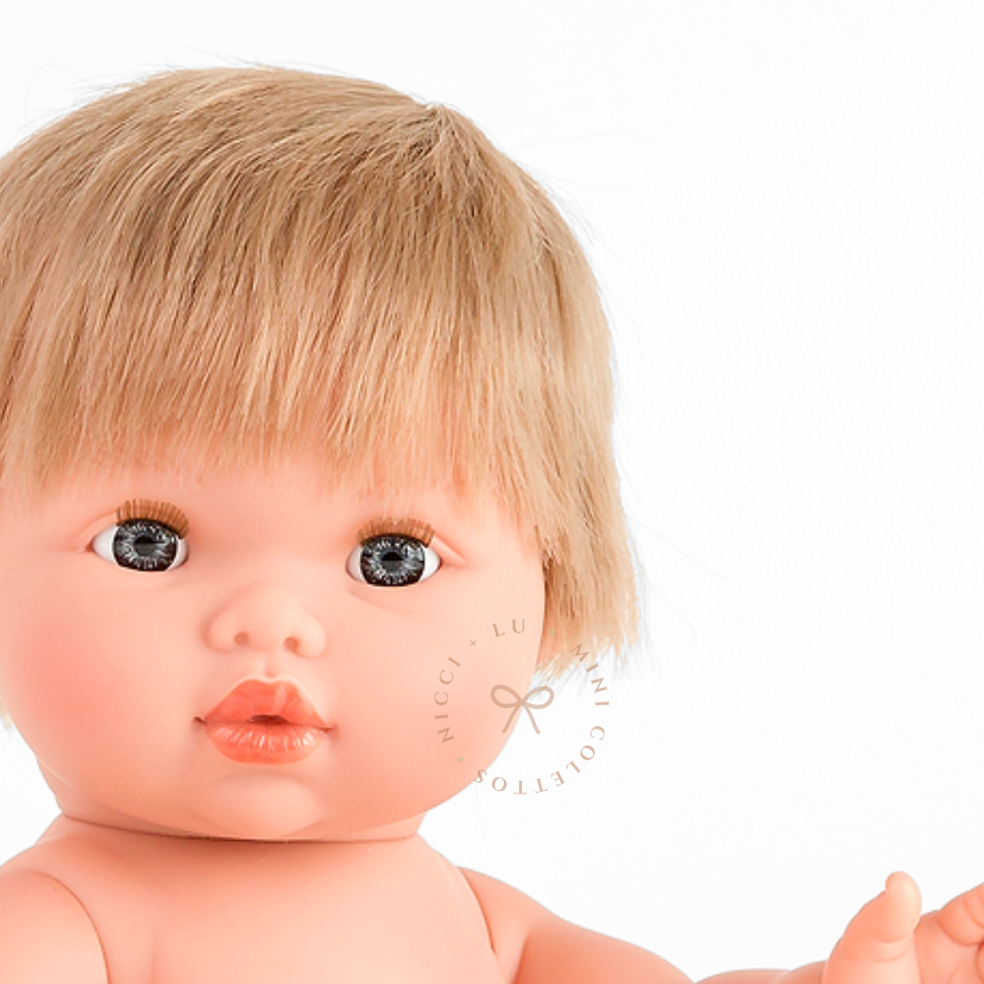 Discover Oliver's sweet facial expression, beautiful blue-grey eyes and neatly cut blonde fringe. This detailed portrait highlights the realistic features of the 34cm Mini Colettos Oliver doll.