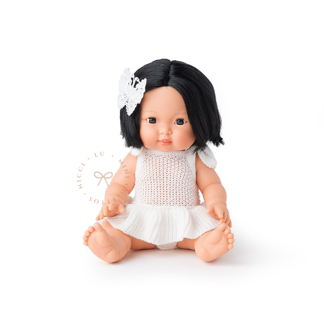 Oshin looks beautiful dressed in a soft Isabella vintage tutu romper in ivory  with a delicate white bow in her short black hair. This styled photograph showcases the charm of dressing the 34cm Mini Colettos doll in sweet miniature outfits and accessories.