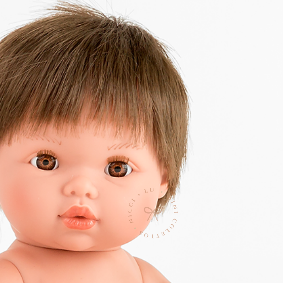 Close-up of Mini Colettos Rafael's face, showing warm brown eyes and a short light brown fringe.
