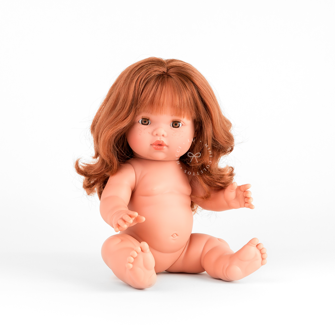 Sophia looks beautiful in a cotton candy smocked bubble romper with a delicate pastel floral hair bow nestled in her flowing auburn curls. This styled photograph showcases the charm of dressing the 34cm Mini Colettos doll in sweet, coordinated outfits and accessories.