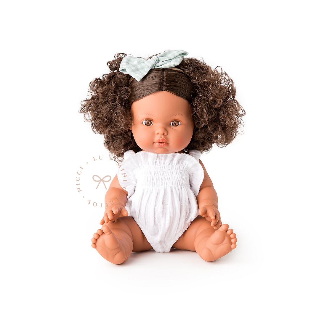 Zaara looks adorable dressed in a soft white bubble romper, finished with a delicate pale bow in her beautiful curly hair. This styled photograph shows how the 34cm Mini Colettos doll can be dressed and accessorised for imaginative play.