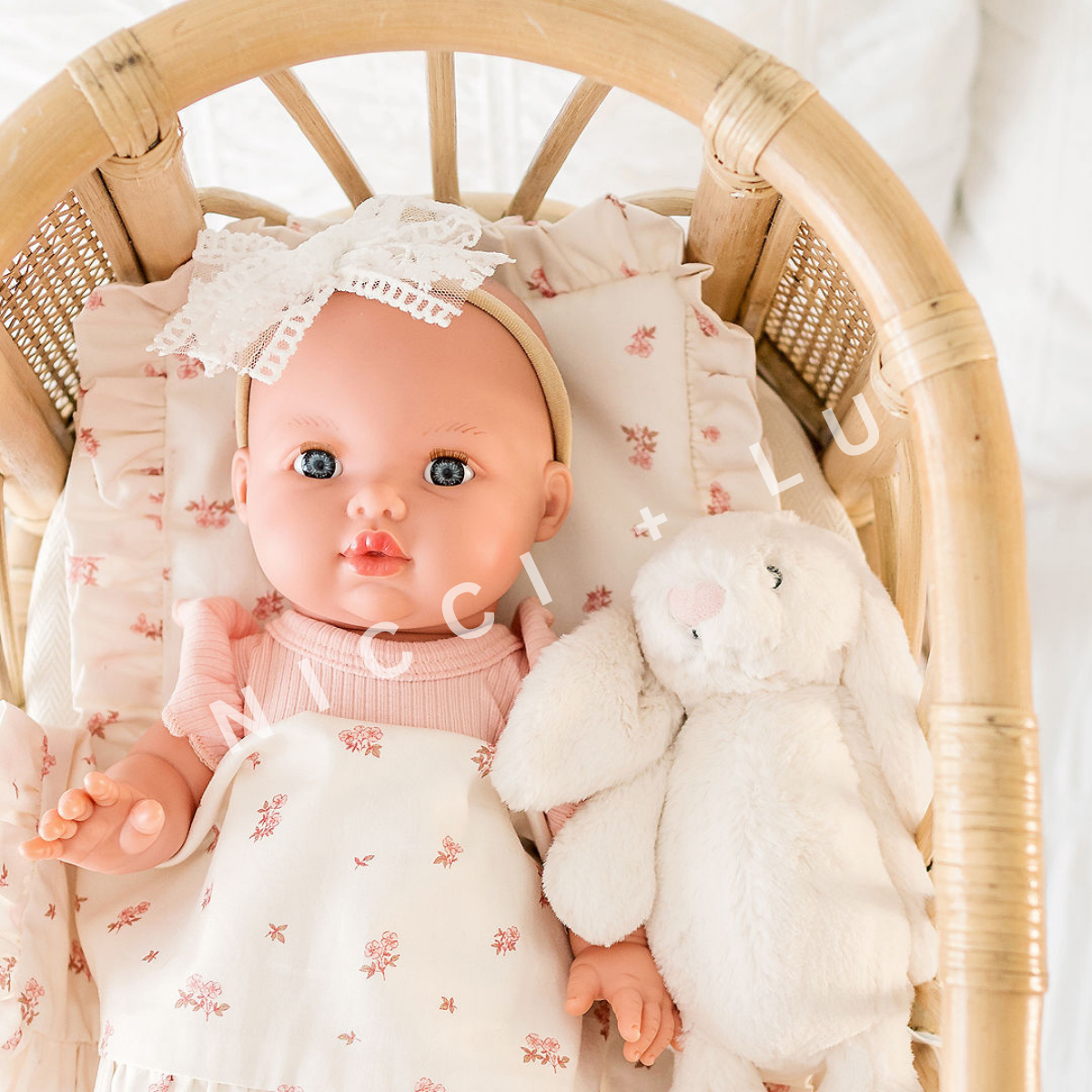 Mini Colettos 34cm Baby doll Mila in a rattan crib with a Jellycat wrapped in a 34cm doll comforter set