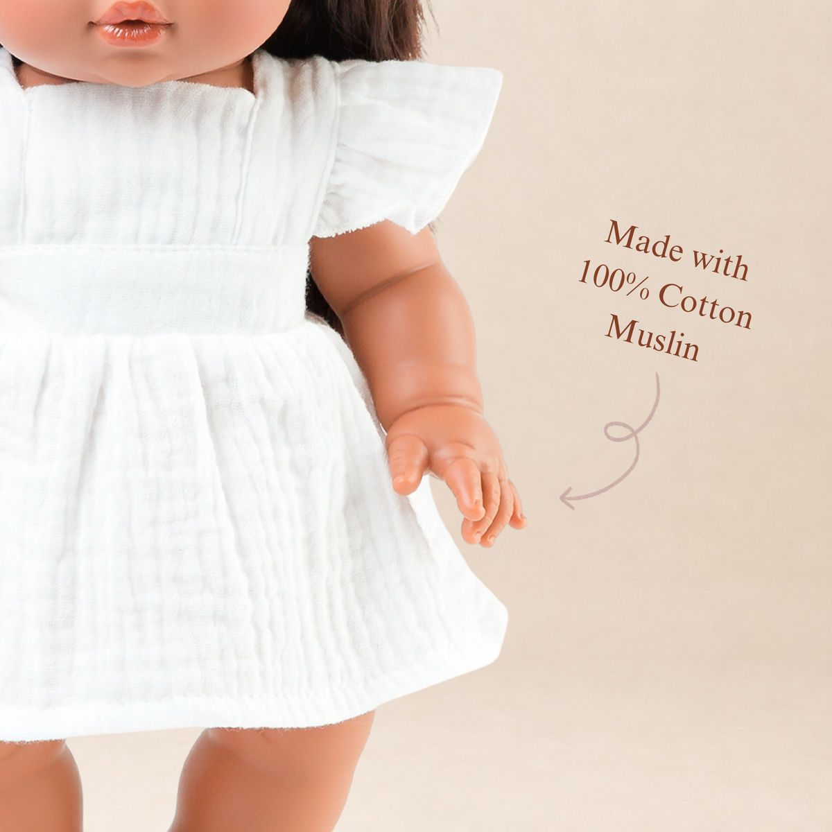 Close-up of the Ivory Pippa Apron Dress highlighting the soft muslin fabric and flutter sleeves.