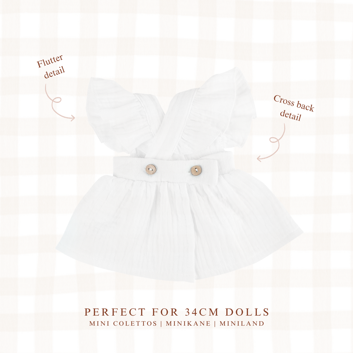 Close-up of the Ivory Pippa Apron Dress highlighting the soft muslin fabric and flutter sleeves.