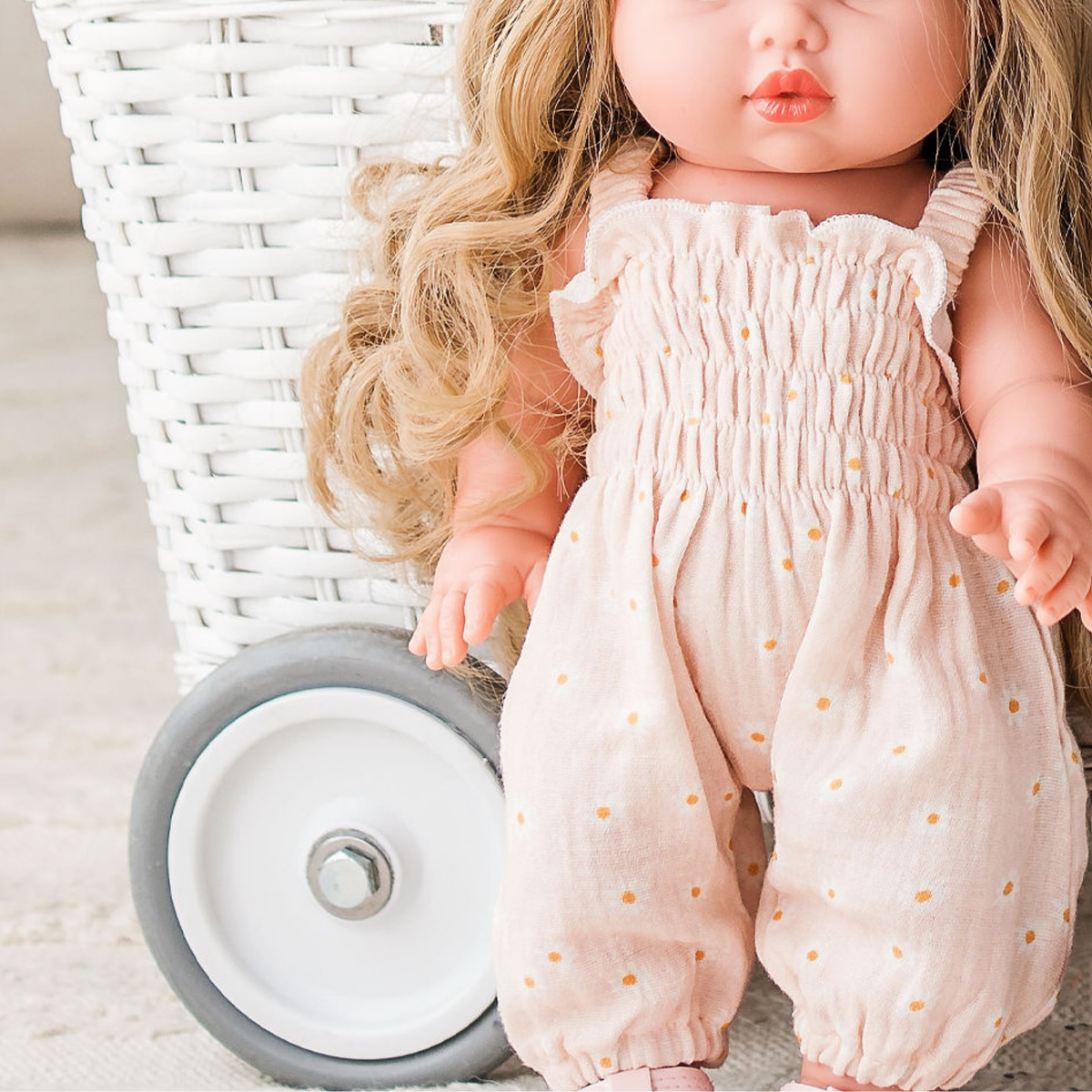 Mini Colettos Lyla wearing the Florence Smocked Jumpsuit in Daisy Print Muslin with the Ballet Pink Fairy Crown.