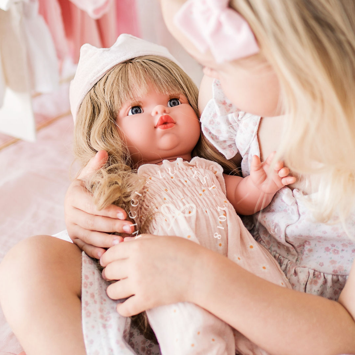 Lifestyle image of Mini Colettos Lyla wearing the Florence Smocked Jumpsuit in Daisy Print Muslin with the Ballet Pink Fairy Crown.