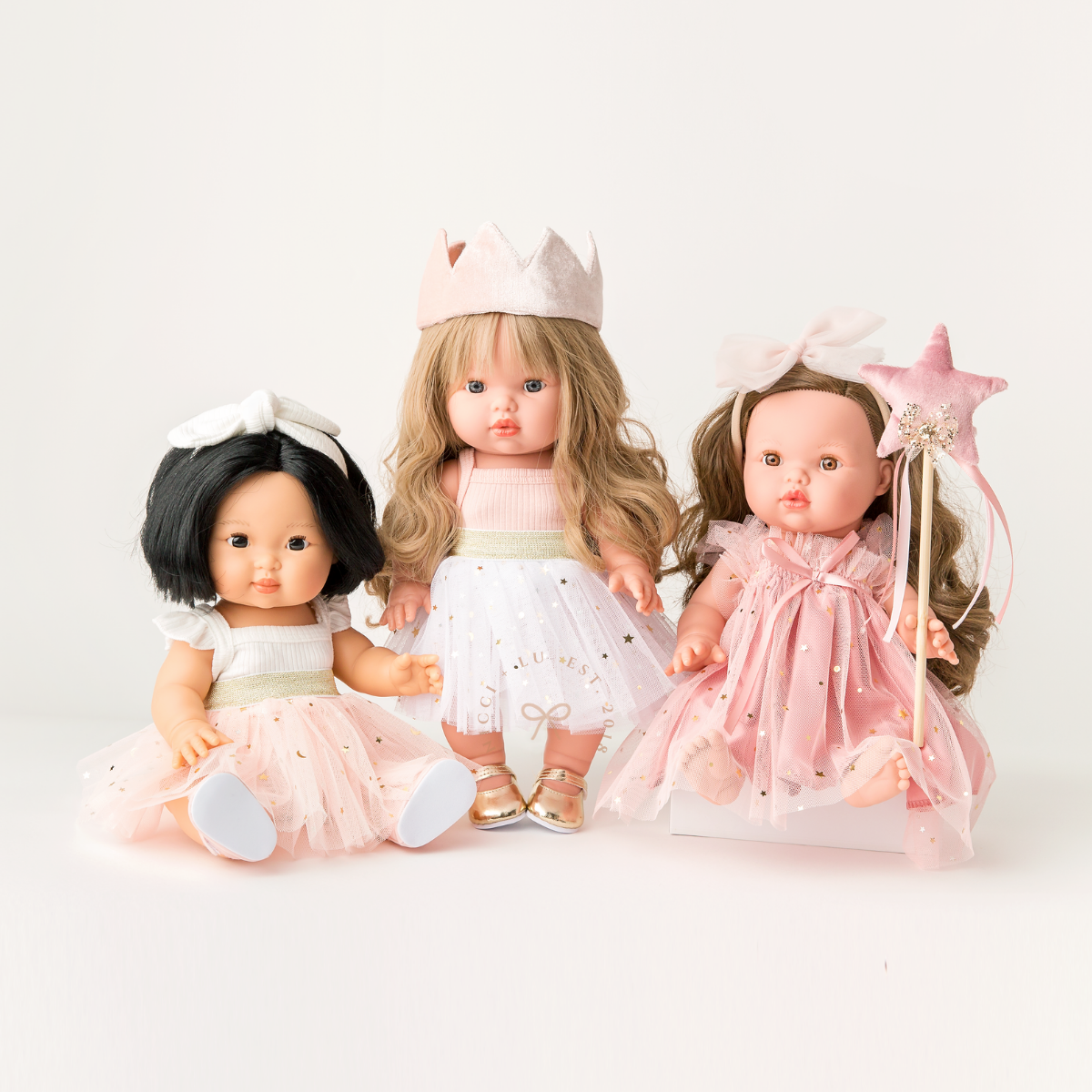 Three 34–38cm dolls wearing Nicci and Lu heirloom-inspired Doll Ballet Dresses and Tutu skirts in Rose Blush, Peach and Ivory.
