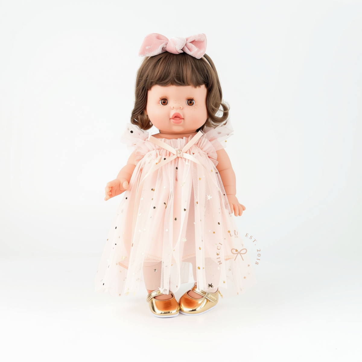 Minikane doll wearing the Peach Doll Tulle Ballet Dress with gold Mary Jane doll shoes.