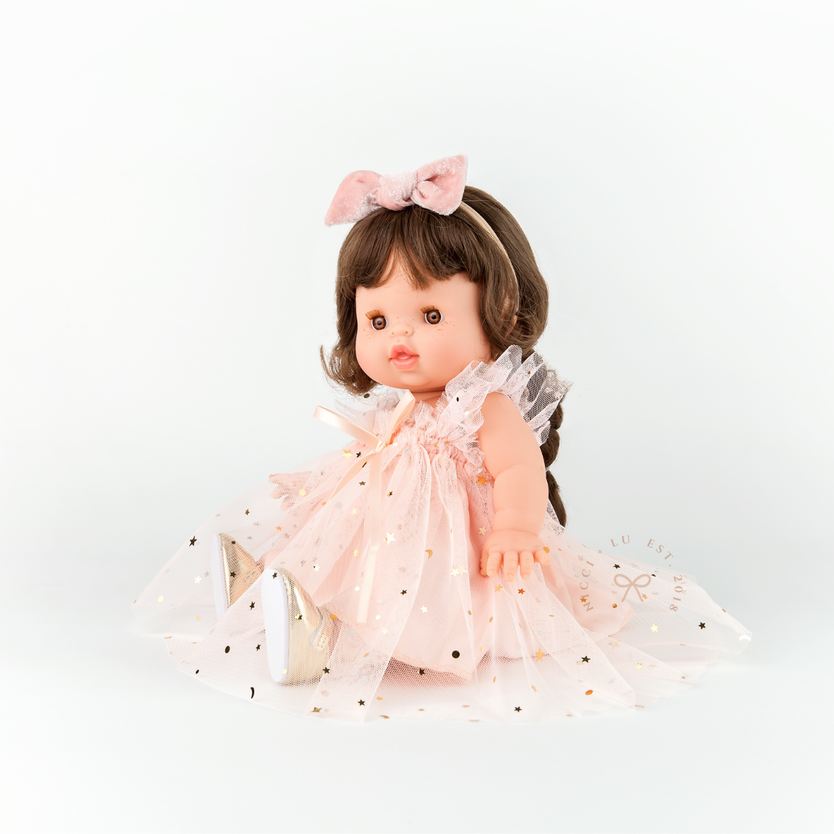 Minikane doll sitting while wearing the Peach Doll Tulle Ballet Dress.