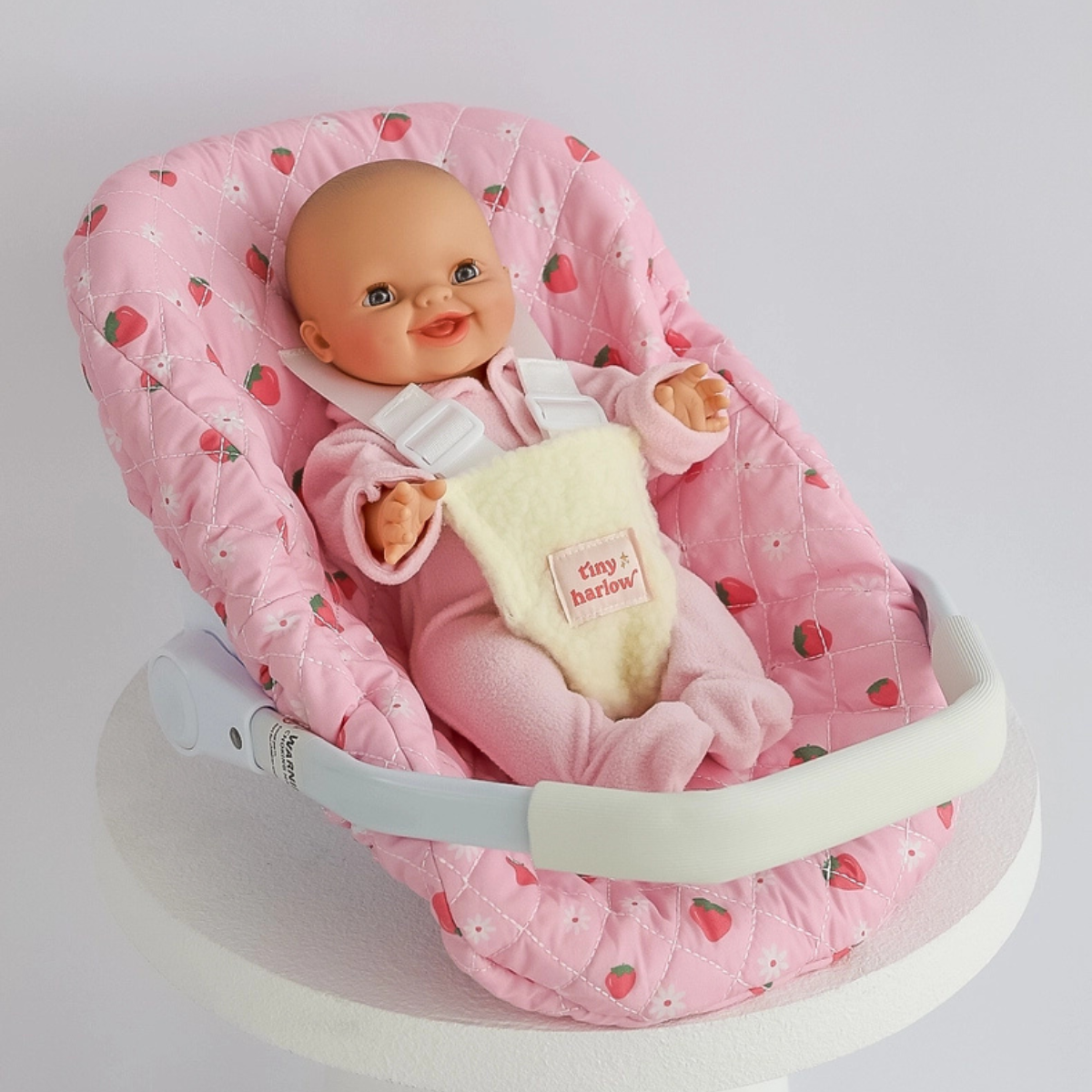 Tiny Harlow Strawberry Picnic doll car seat capsule with doll secured inside