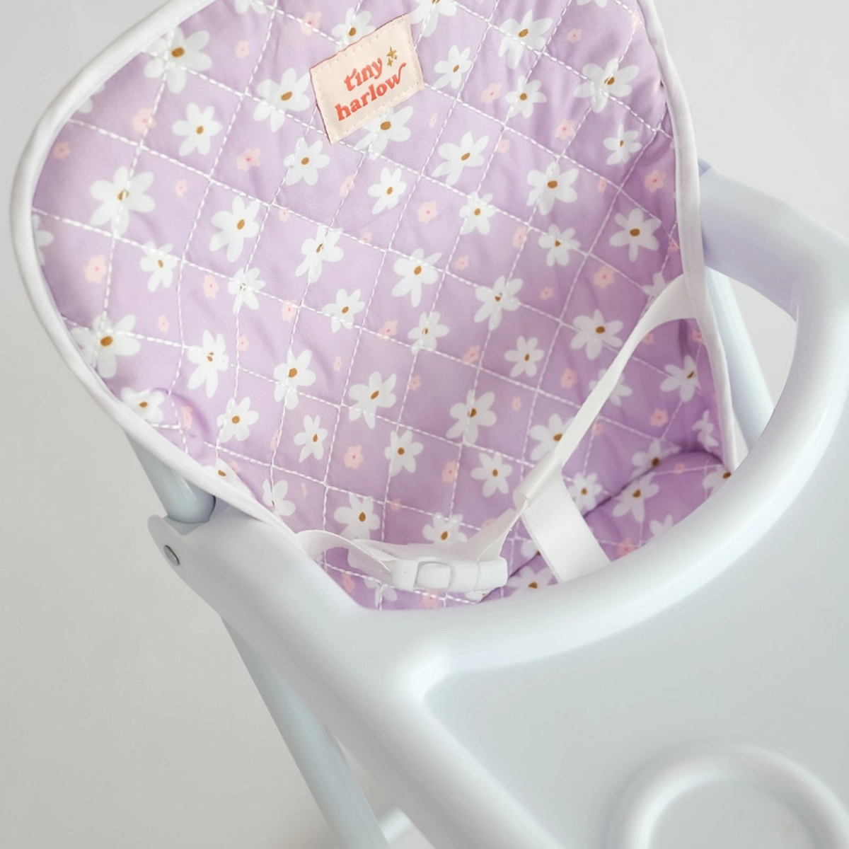 Close-up of the lilac daisy seat and tray on the Tiny Harlow doll highchair.