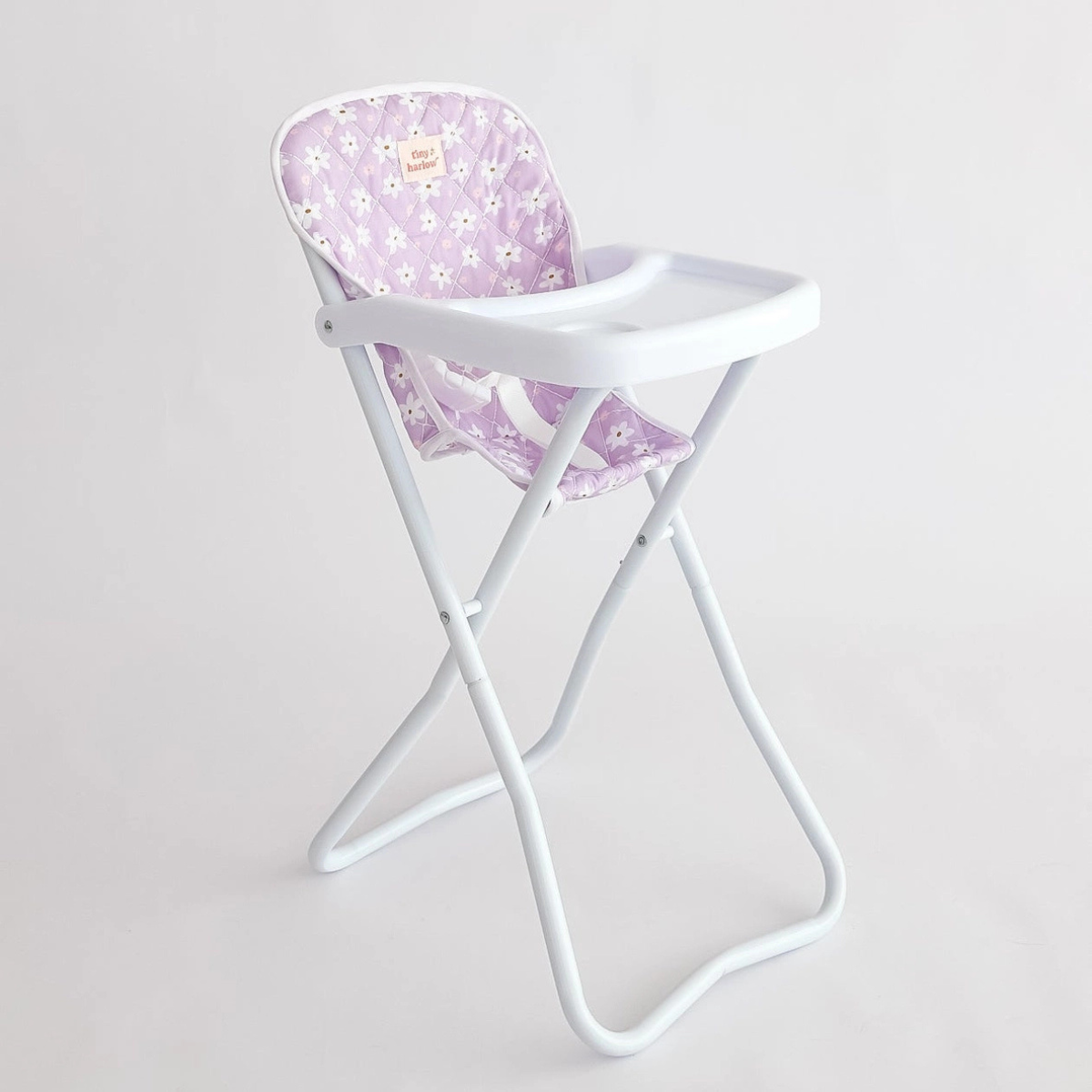 Tiny Harlow lilac daisy doll highchair shown from an angled view.