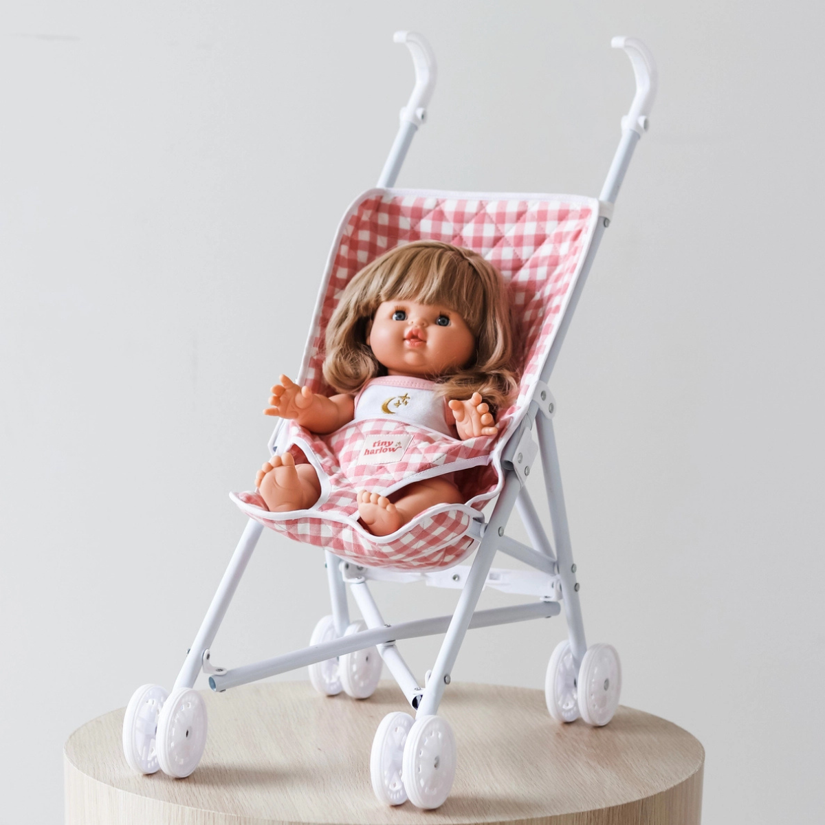 Tiny Harlow Pink Gingham Folding Doll Stroller with doll seated inside